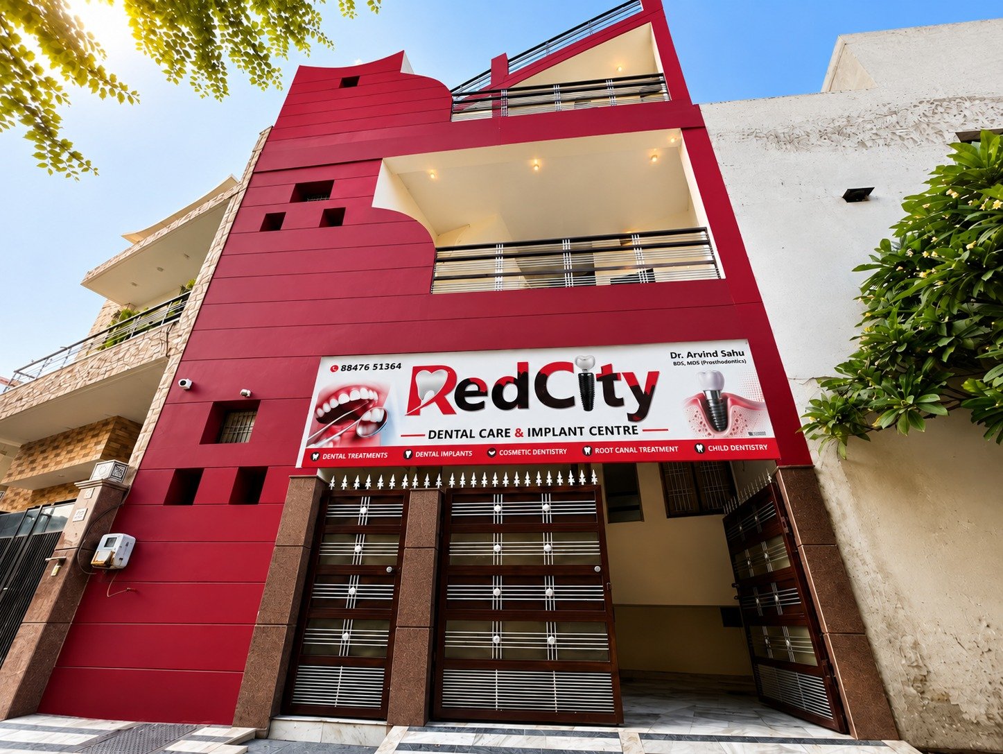 The RedCity Dental Care & Implant Centre building on South Model Gram, Ludhiana — a red-panelled three-storey clinic with the RedCity signage above the entrance